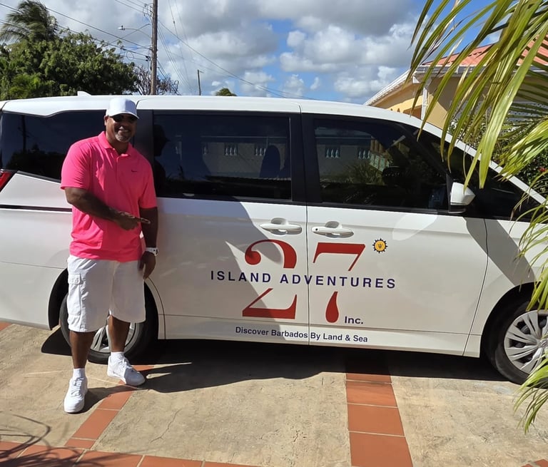 Man in pink shirt standing next to white Island Adventures tour van