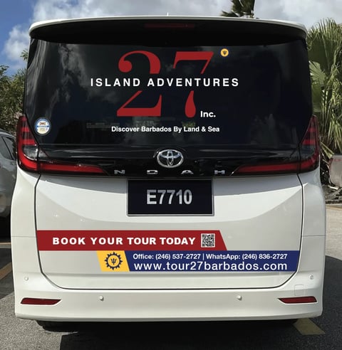 Rear view of white and red tour bus with Island Adventures 27 logo, displaying contact info and website